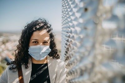 Portrait of young woman against blurred background