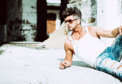 Young man wearing sunglasses sitting outdoors