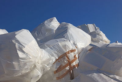 Low angle view of closed plastic bags against clear sky