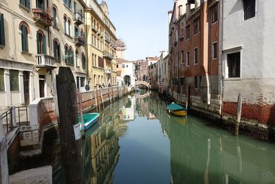 Boats moored in canal along buildings