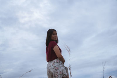 Low angle view of woman standing against sky