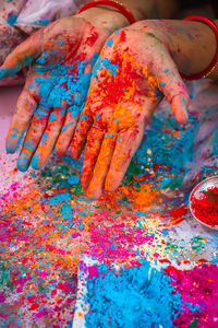 Colorful hand at holi celebration with multicolor from flat angle