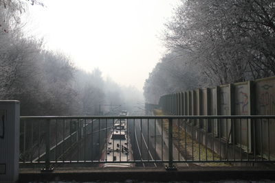 Bridge over river against sky during foggy weather