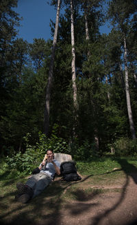 People sitting by trees in forest