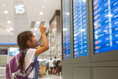 Cute girl looking at arrival departure board