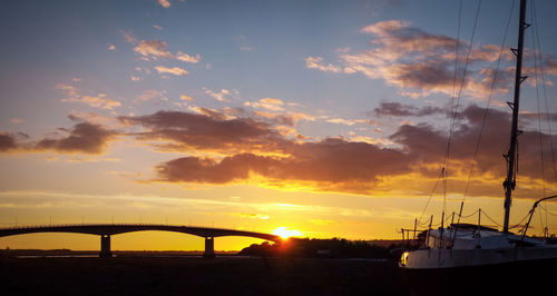 Silhouette of bridge over sea during sunset