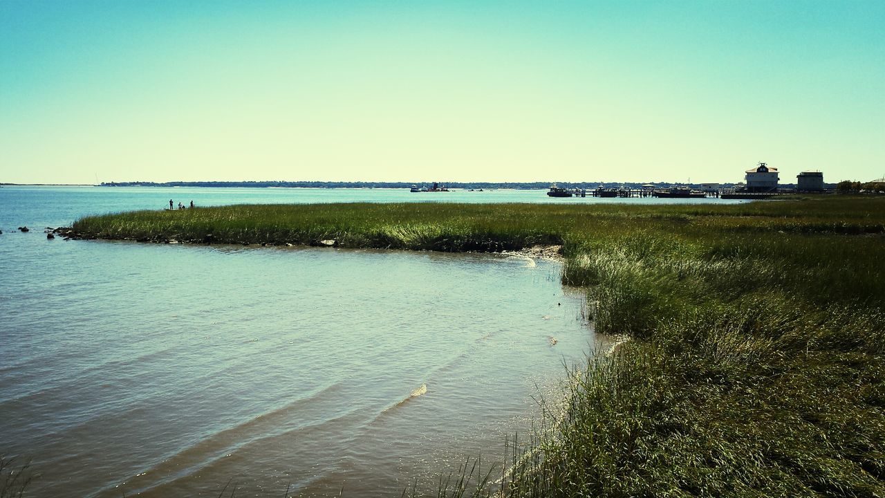 clear sky, water, copy space, sea, tranquil scene, tranquility, blue, scenics, beach, nature, beauty in nature, horizon over water, waterfront, shore, reflection, building exterior, idyllic, built structure, rippled, outdoors