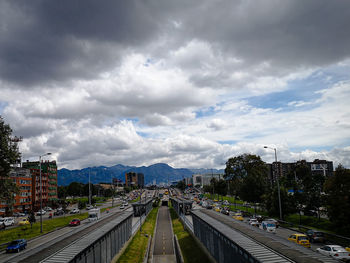 High angle view of vehicles on road against cloudy sky