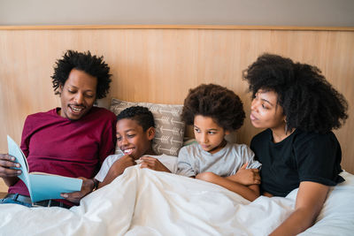 Cheerful family lying on bed at home