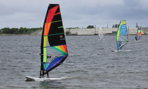 Boats in sea with buildings in background