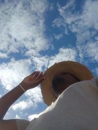 Low angle view of human hand against sky