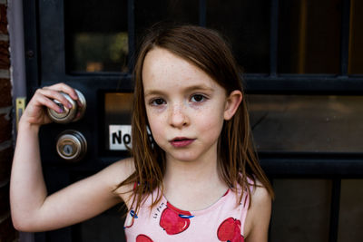 Content young girl holding on to front door