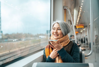 Portrait of young woman sitting in train