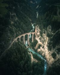 Aerial view of arch bridge over river amidst mountains