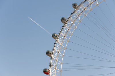 Low angle view of ferris wheel against clear blue sky