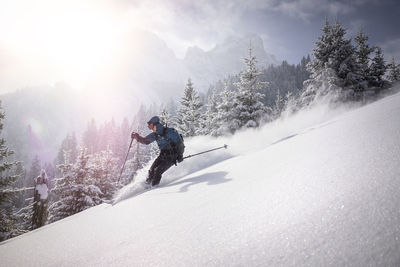 Man moving down from snowy mountain while skiing during winter