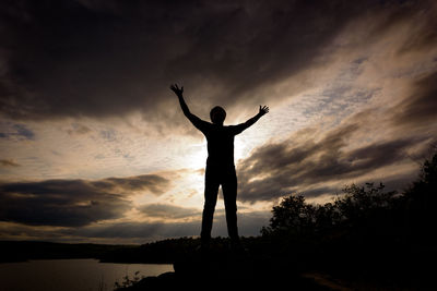 Rear view of silhouette man standing against sky during sunset