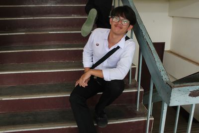 Portrait of young woman sitting on staircase