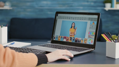 Cropped hand using laptop on table