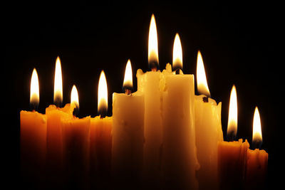 Close-up of burning candles in darkroom