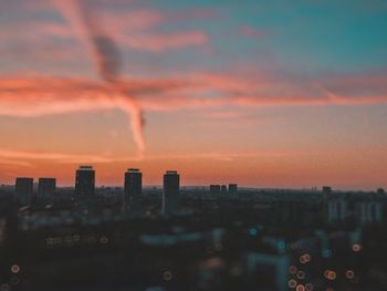 Scenic view of buildings against romantic sky at sunset