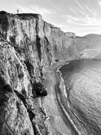 Rock formations by sea against sky