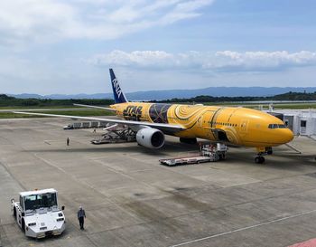 Airplane on airport runway against sky