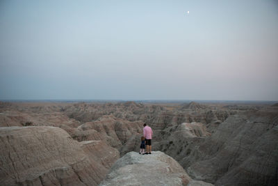 Rear view of man on rock against sky