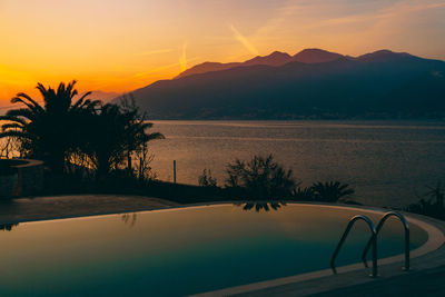 Scenic view of swimming pool against sky during sunset