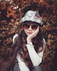 Portrait of smiling young woman wearing sunglasses while standing outdoors