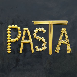 Pasta, word made with food on black table