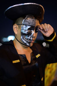 Young man wearing pirate costume standing against sky at night