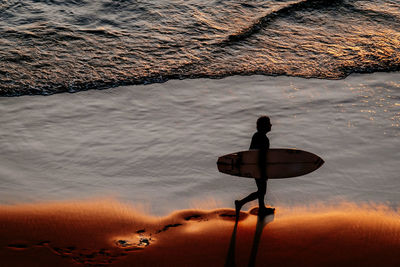 High angle view of man at beach during sunset