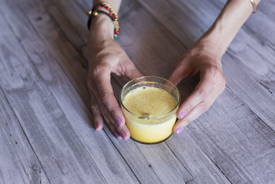 High angle view of woman holding drink on table