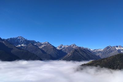 Scenic view of snowcapped mountains against clear blue sky