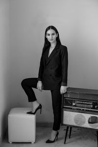 Portrait of confident businesswoman standing against wall