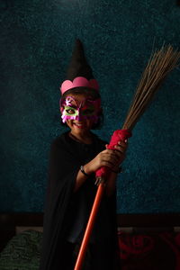 Full length portrait of woman standing against wall