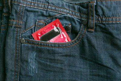 High angle view of condom in jeans pocket