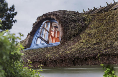 Woman at window looking through binoculars