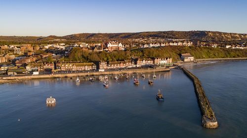 Aerial view of townscape by lake against clear blue sky