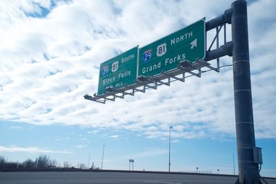 Low angle view of road sign against sky