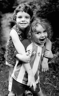 Portrait of happy siblings playing at park
