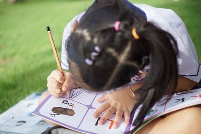 Close-up of girl studying in park