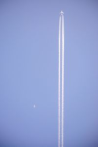 Low angle view of vapor trail against clear blue sky