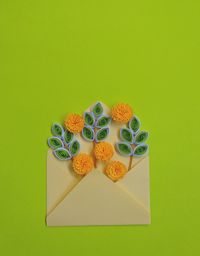 Handmade paper quilling flowers in yellow envelope with green background