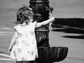 Girl playing with fountain in park