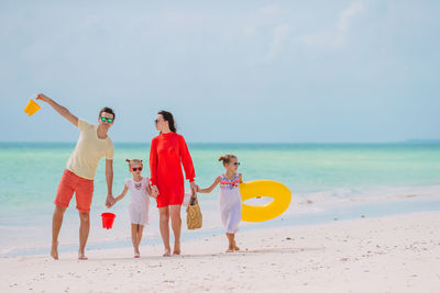 People on beach by sea against sky