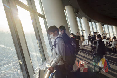 Group of people standing by the window