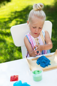Close-up of cute girl holding baby while sitting outdoors