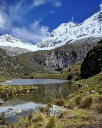 Scenic view of lake and snowcapped mountains against sky